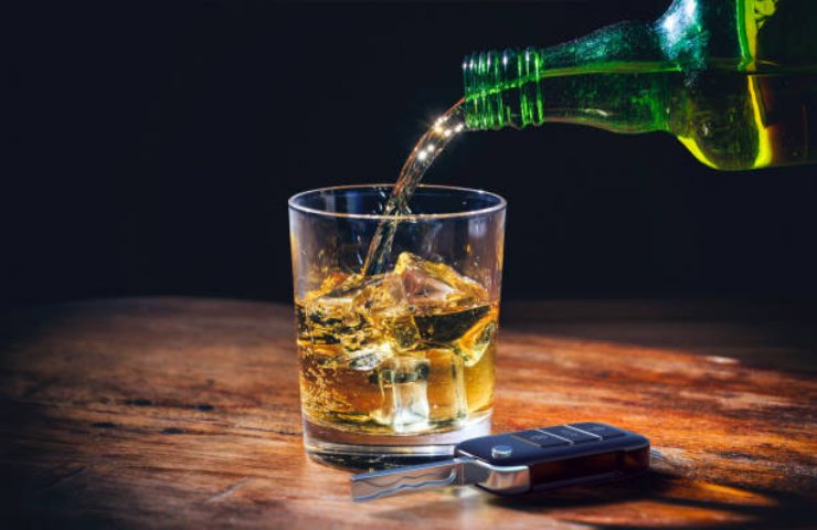 Bicchiere di alcol e chiavi della macchina poggiate su un tavolo