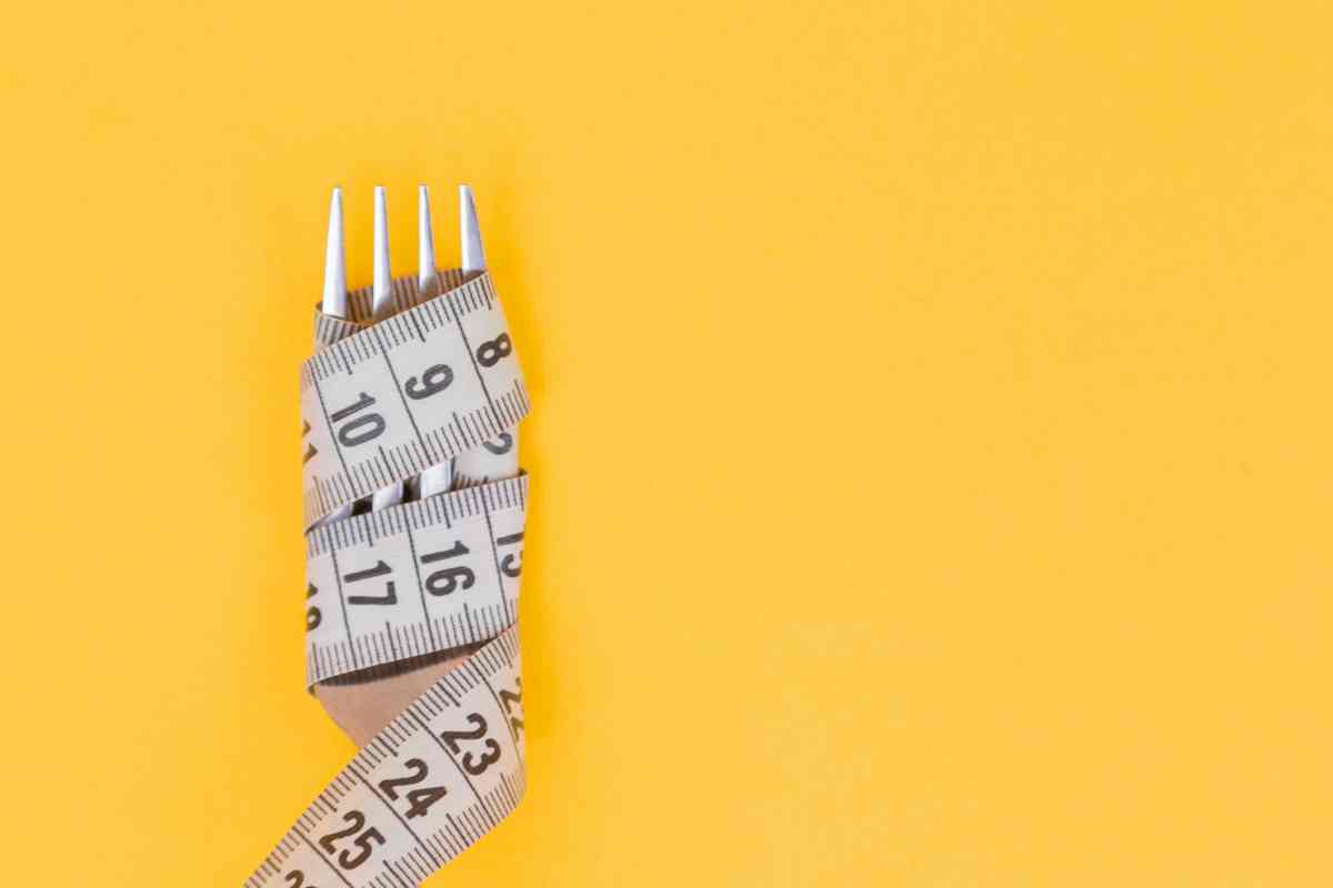 Immagine di una forchetta avvolta in un metro da sarta