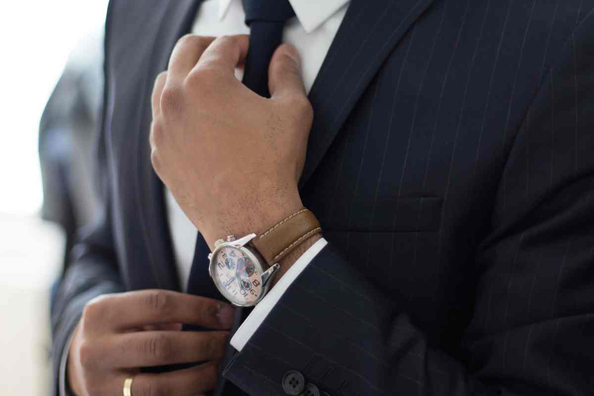 Foto di un uomo vestito elegante con l'orologio al polso