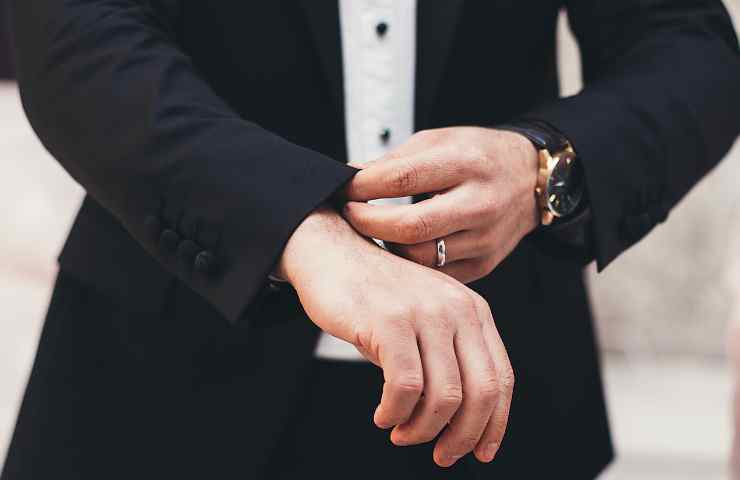 Foto di un uomo vestito elegante con l'orologio al polso