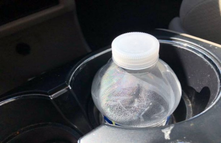 Bottiglia di plastica nel porta bicchieri della macchina