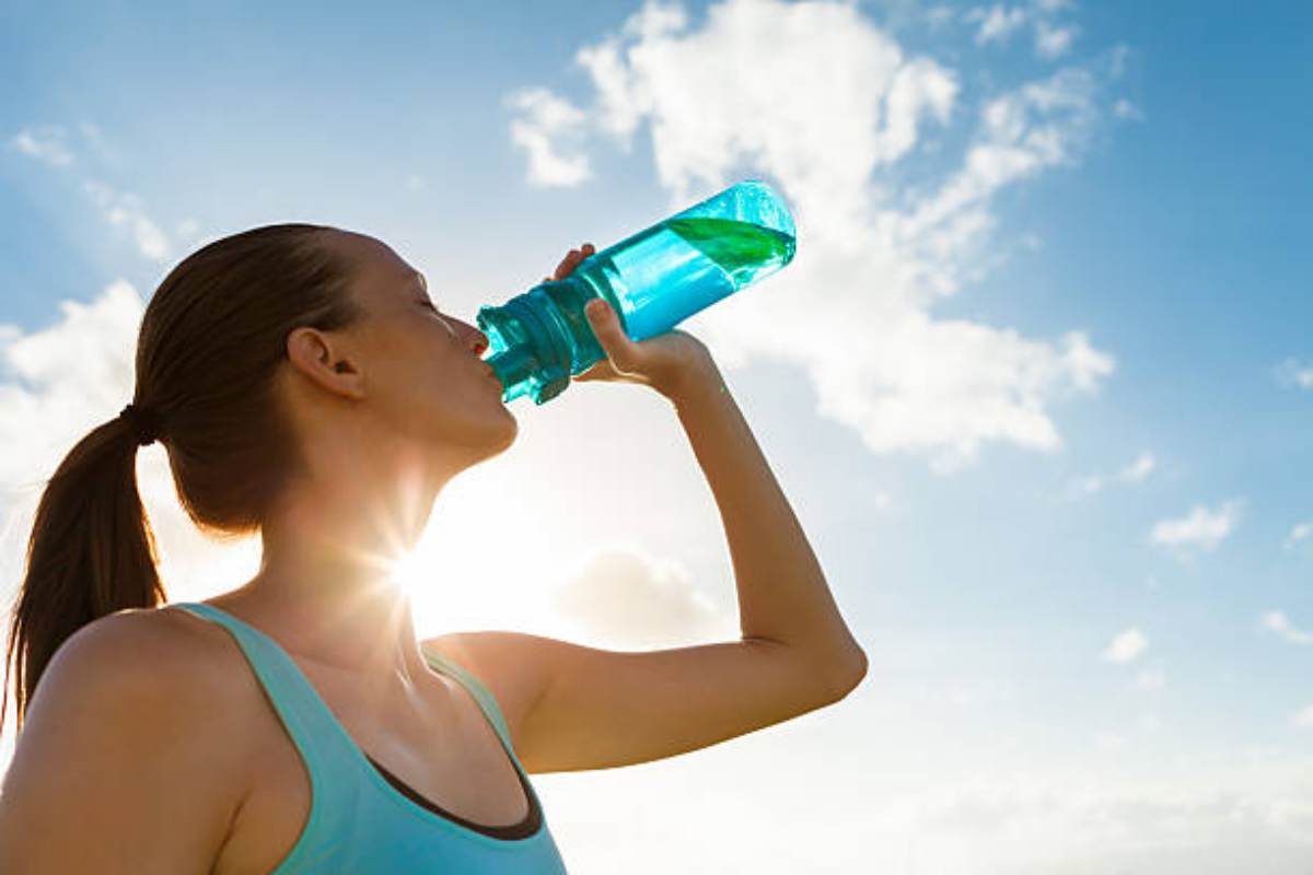 Sportiva che beve acqua proteica
