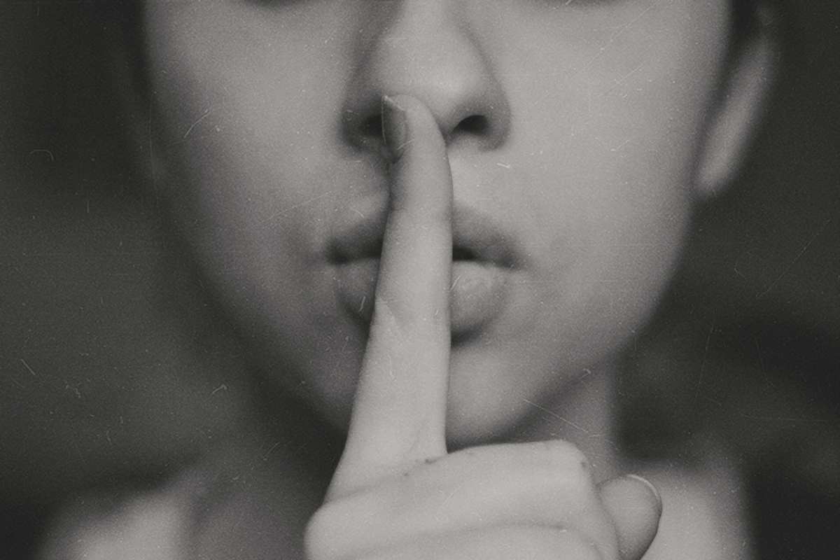 Donna porta il dito alla bocca per dire di fare silenzio