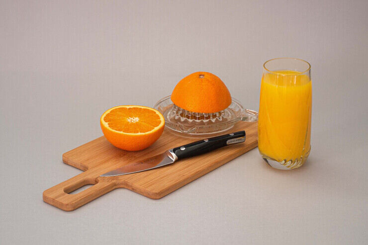 Spremuta d'arancia con arance su un tagliere 