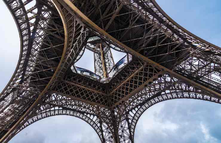 Vista dal basso della Tour Eiffel e del suo ferro battuto in una giornata mediamente nuvola