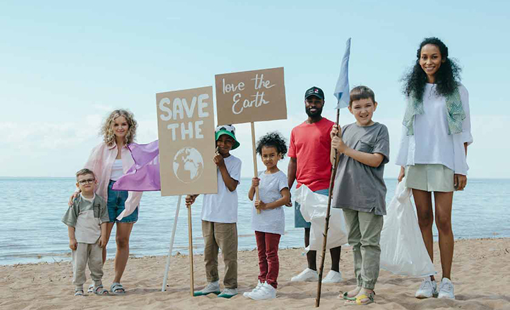 dei bambini tengono dei cartelli sul cambiamento climatico sulla spiaggia