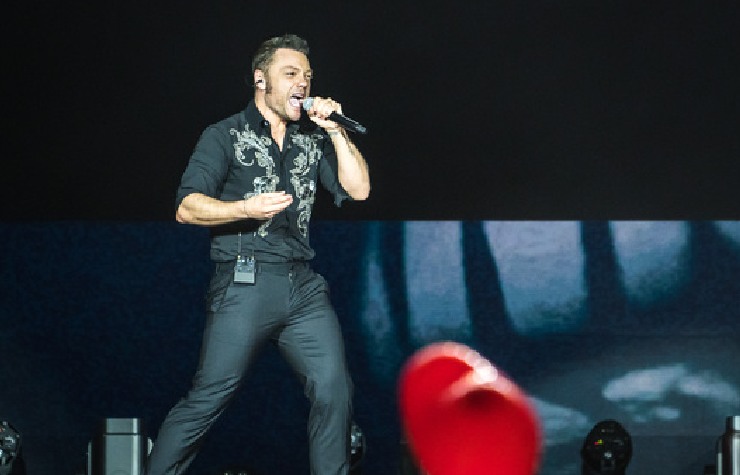 Tiziano Ferro che canta vestito di nero sul palco dell'olimpico