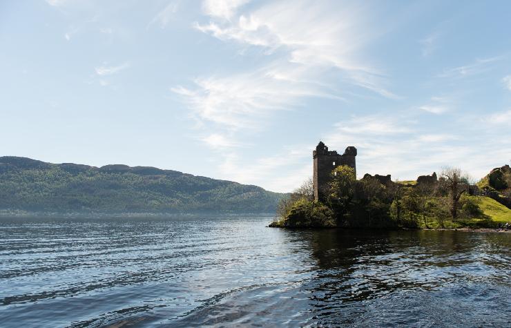 Lago scozzese con un castello medioevale a lato destro