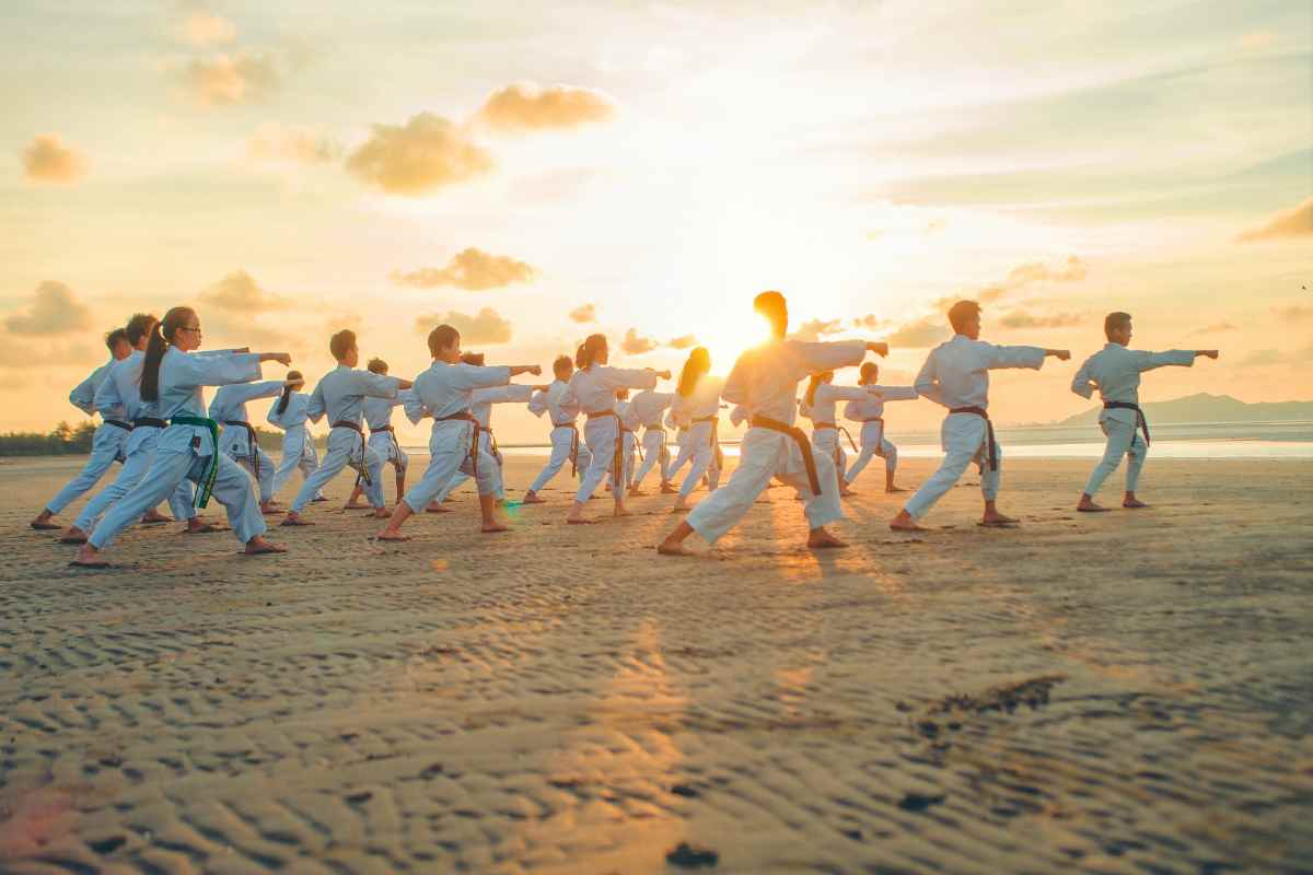 Allievi praticano karate sulla spiaggia