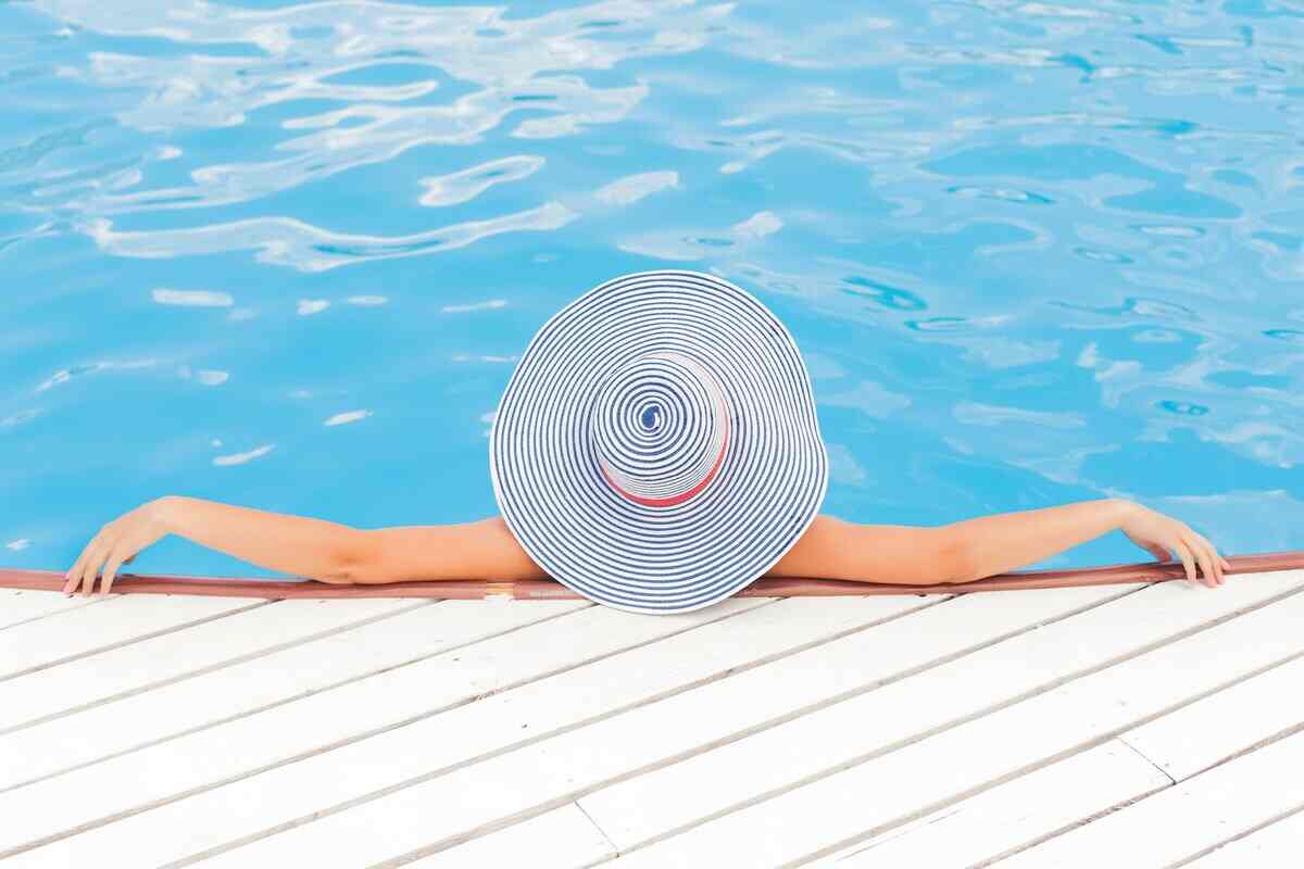 ragazza in piscina con cappello